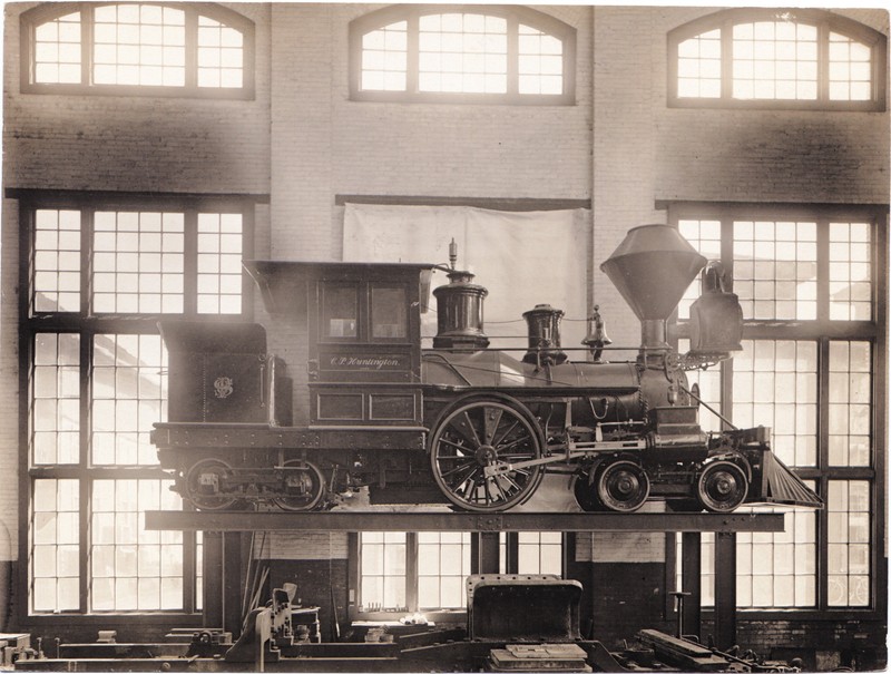 Southern Pacific RR's "C.P. Huntington" locomotive elevated for maintenance in 1907. Huntington was a founder of the Central Pacific and later president of the Southern Pacific. This locomotive is now on display at the Railroad Museum.