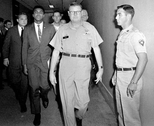 Heavyweight champion Muhammad Ali is pictured being escorted from the Armed Forces Examining and Entrance Station in Houston, Texas, April 28, 1967, by Lt. Col. J. Edwin McKee, commandant of the station, after Ali refused Army induction.