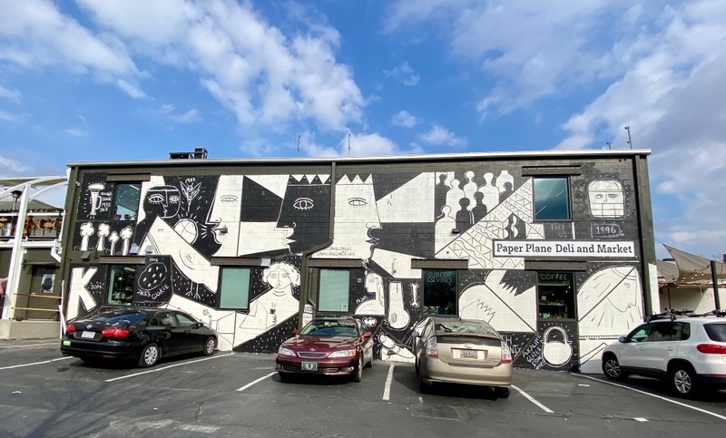 White portraits, shapes that tell the history of Charlotte are painted on a black background.