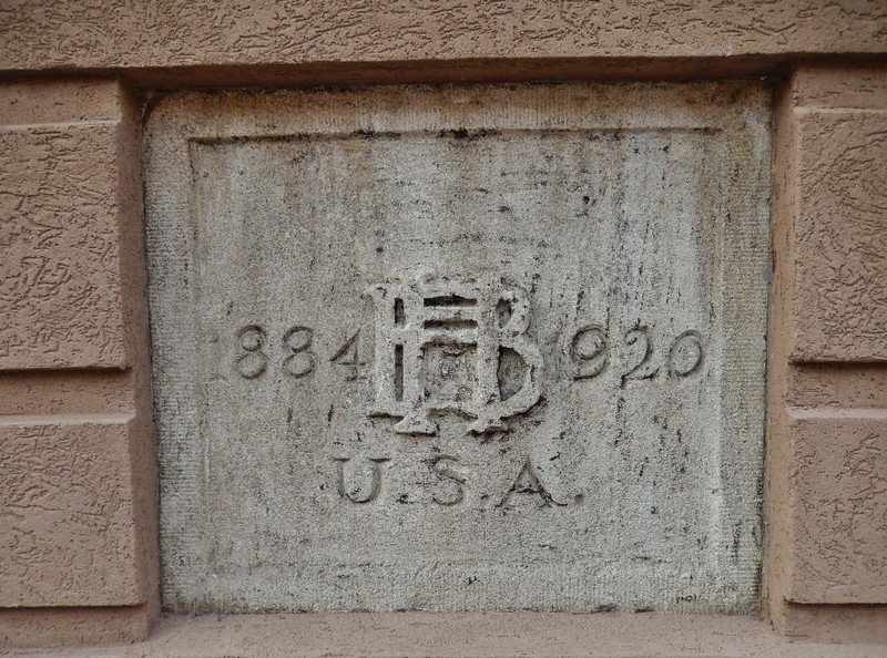 HB insignia/medallion on side of building.