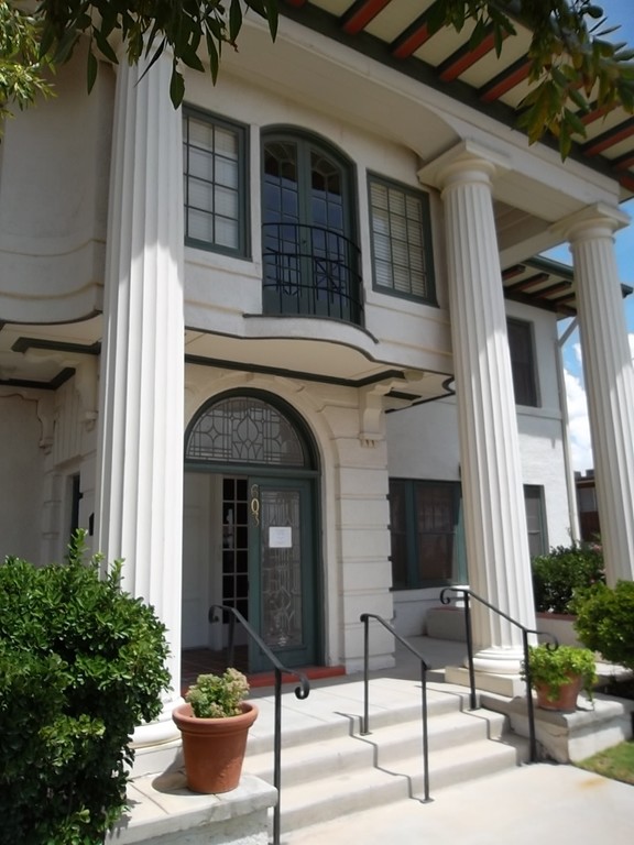The Classical Revival style house features four large columns in the front supporting the roof. 
