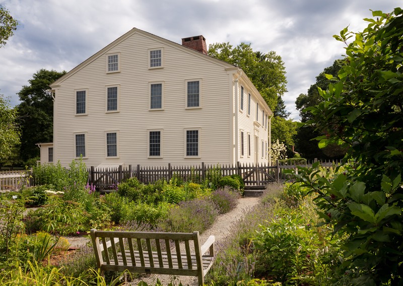 A view of Smith's Castle from the side with a garden in the foreground.