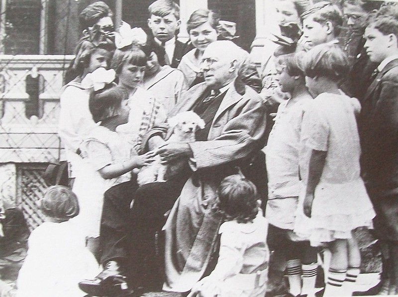 James Whitcomb Riley holds his pet dog while posing for a photo with a group of children in front of his Indianapolis home in 1916. Courtesy of the State of Indiana. 