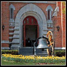 Church Main Entrance and Bell Photo with spring Daffodil flowers in the background, provided by Bob Neill, Church Member.