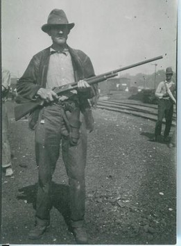 A white man poses with his rifle during the riot. He may have been part of the mob, or he may have been part of the deputized police force raised among the city's white male population. 