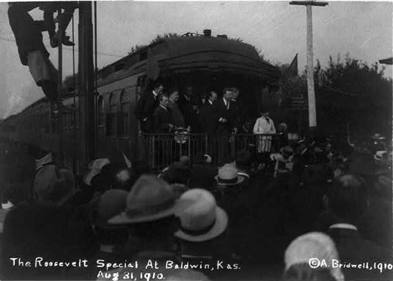 1910 photograph of Teddy Roosevelt speaking from back of The Roosevelt Special at the Baldwin City Depot (Library of Congress)