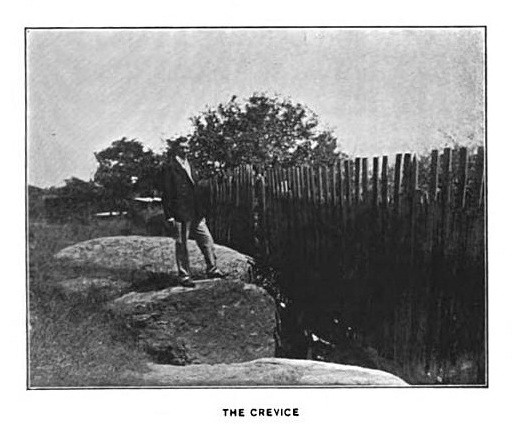 Sidney Perley standing at the crevice near Proctor's Ledge where the bodies of those executed were thrown
