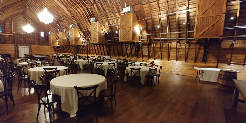 The hayloft serves as the main event center. The large boxes on the wall contain heating and air conditioning units. The roof and wooden trusses are all the same wood from when it was first created in 1935. Photo taken May 6, 2020.