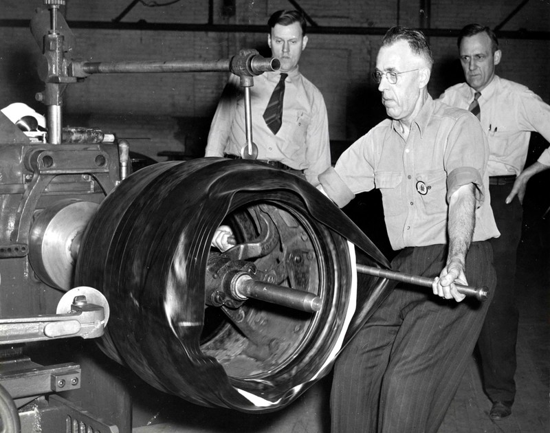 William McNair rolling on tread during tire construction (1944)