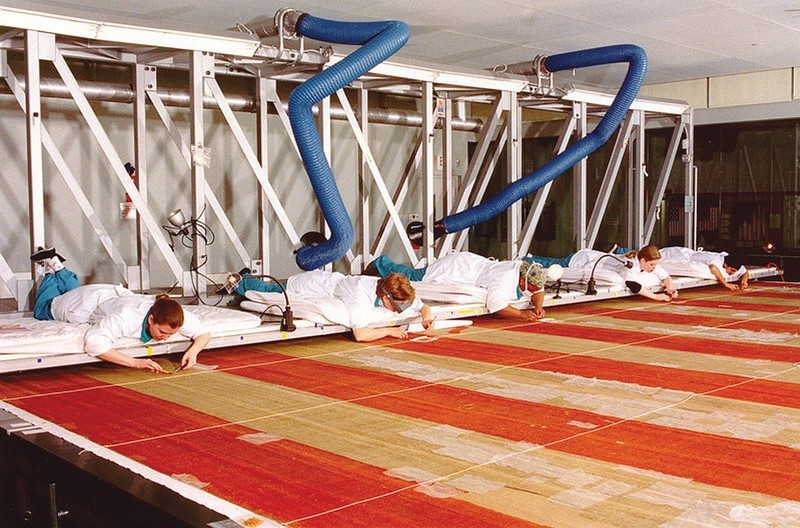 Conservators meticulously work on the Star-Spangled Banner. It is now on display in an environmentally-controlled gallery for many generations of visitors to enjoy. Photo courtesy of the National Museum of American History.