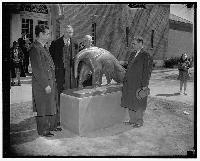 Artist Edwin Springweiler, Dr. Alexander Wetmore of the Smithsonian Institution, Head Keeper William Blackburn, and Dr. William M. Mann, Director of the National Zoological Park, unveil the anteater statue in 1938. Library of Congress.