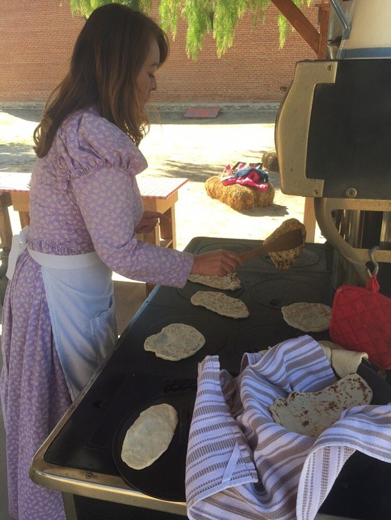 An interpreter makes tortillas for visitors