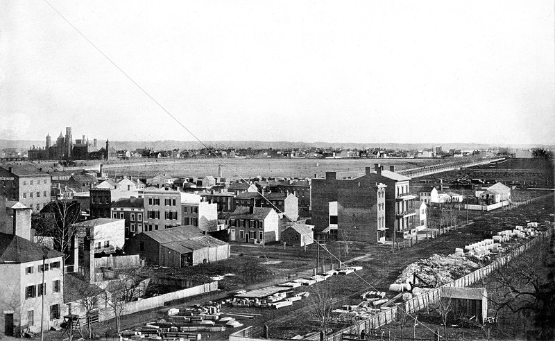 The Castle rises from the empty National Mall. A canal once separated the Castle from the picture foreground, where construction materials for the new Treasury Building rest on 15th Street, NW. Courtesy of the Smithsonian Institution Archives. 