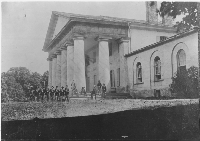 Arlington House came under Union occupation beginning in May 1861. In this image from 1864, Union soldiers pose on the grand front porch of the mansion. National Archives.