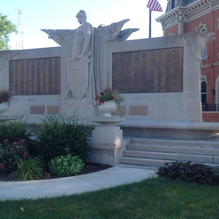The front of the Peace Monument. Female peace standing in the center, and the bronze panels located on the left and right with the veterans names.