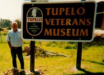 Tony Lute standing next to the museum sign