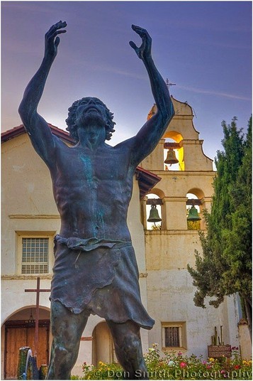 A statue of San Juan Bautista's namesake, St. John the Baptist, in front of the mission.