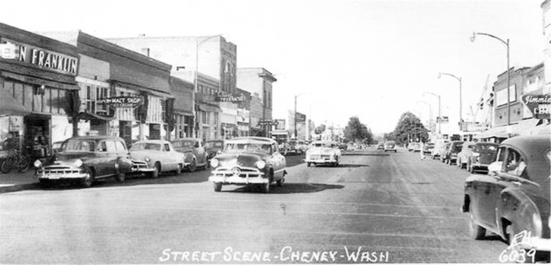 cars pass the Malt shop, at left