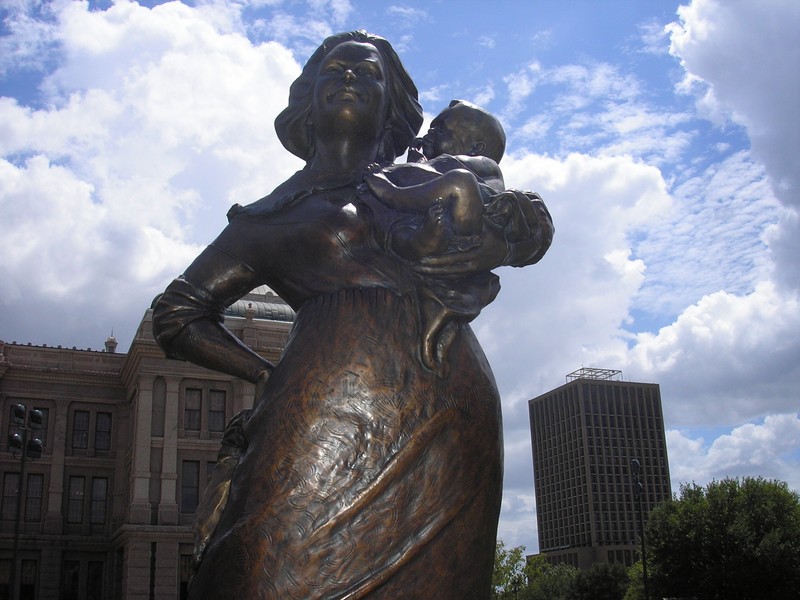 Bronze statue of a woman holding a baby