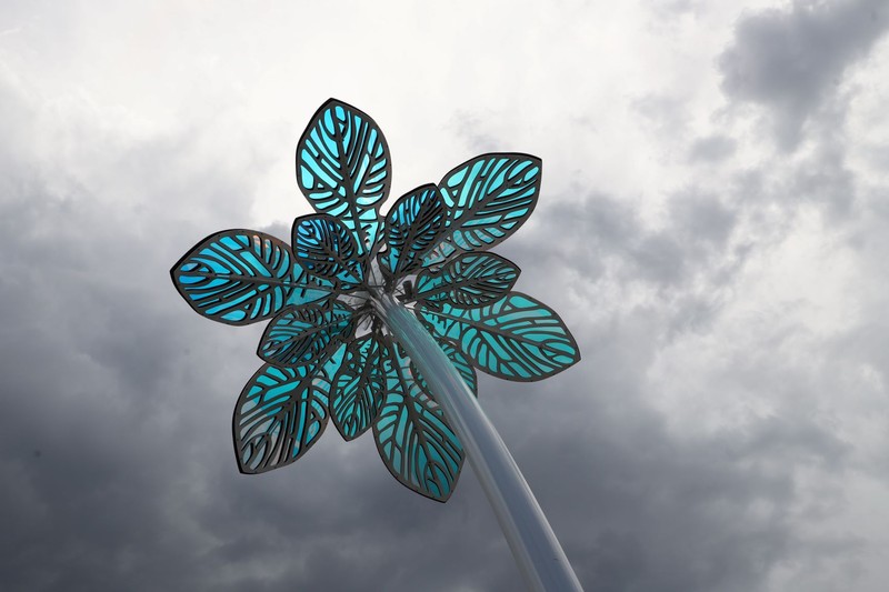 Photo of flower sculpture with stormy lighting causing glass petals to appear shades of green.