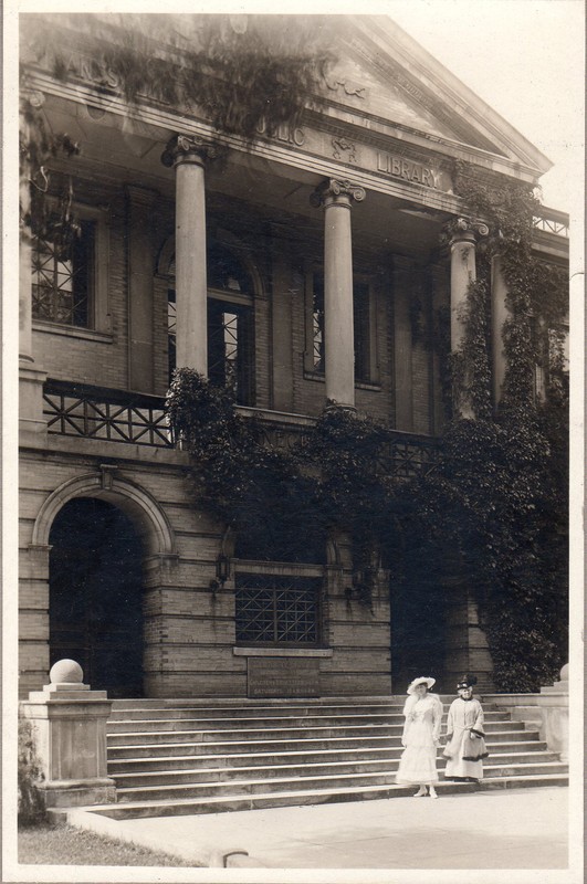 Two women in front of the library at the turn of the century