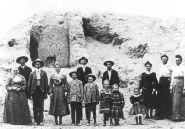 The Lewis family, in front of the mound at Mesa Grande in 1904, carried out excavations to see what was inside.  They found a series of thick caliche walls.