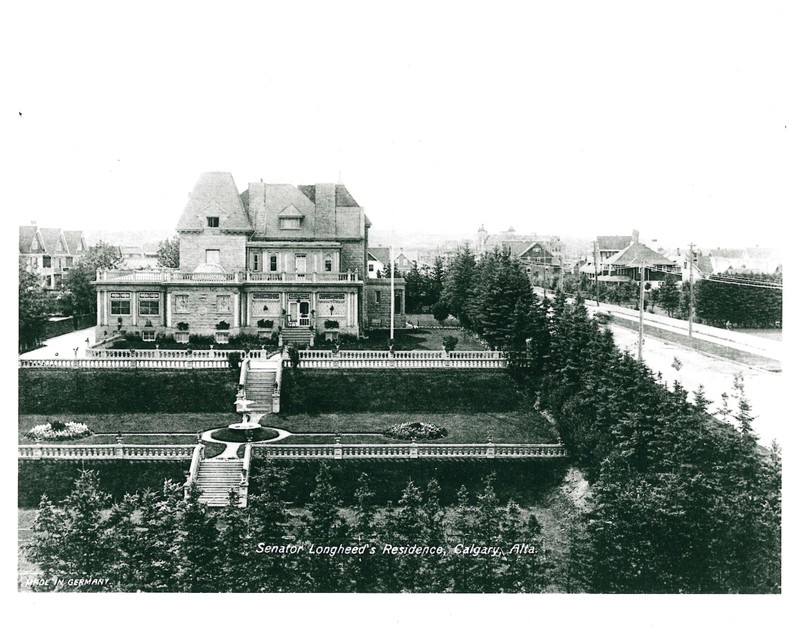 Black and white image of sandstone mansion, with tiered formal gardens in foreground