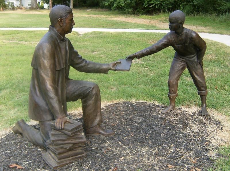 A chaplain hands a book to a young boy.