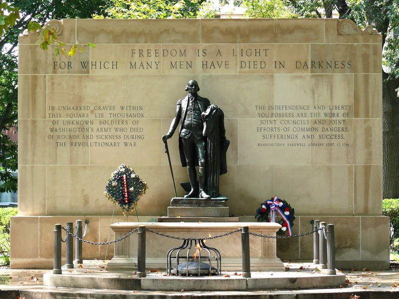 Standing over the tomb in a guardian-like pose is a bronze statue of George Washington.