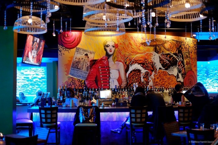 The full bar available to customers in front of one of two beautiful murals inside the restaurant. 