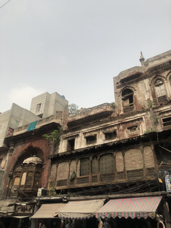 Wide angle view of the facade of the complex, with shuttered windows and the jharokha