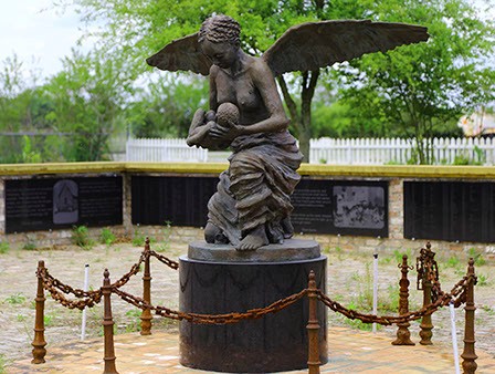A Black angel carrying a baby to Heaven.