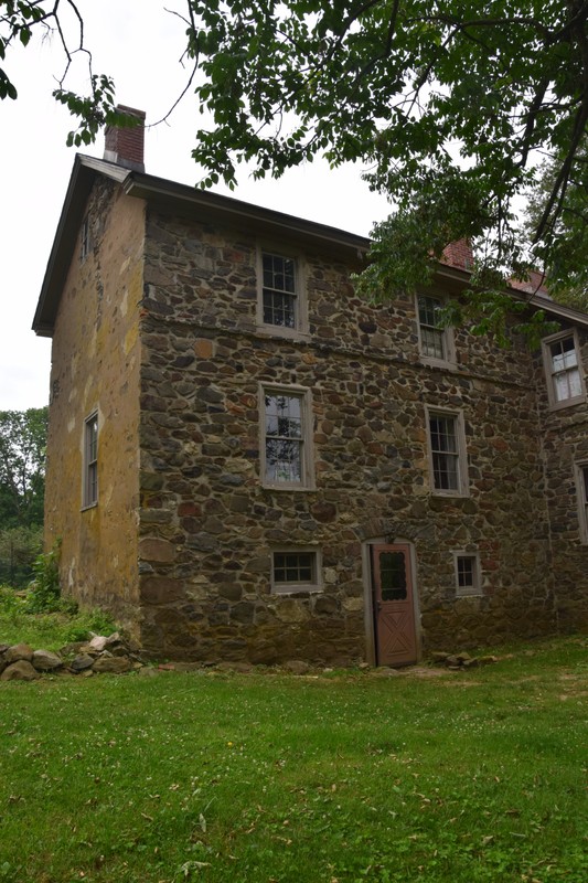 Image of 3-story stone house with two bays of windows and a door in the center