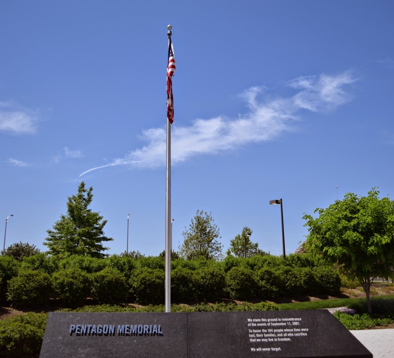Flag pole w/ an inscription that reads, "We claim this ground in remembrance of the events of September 11, 2001. To honor the 184 people whose lives were lost, their families, and all who sacrifice that we may live in freedom. We will never forget."