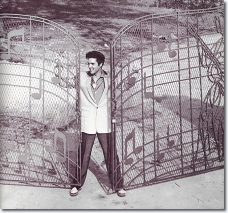 Elvis standing at the music gate that was custom designed and built for him. The gate was installed in 1957 shortly after Elvis moved into the home.