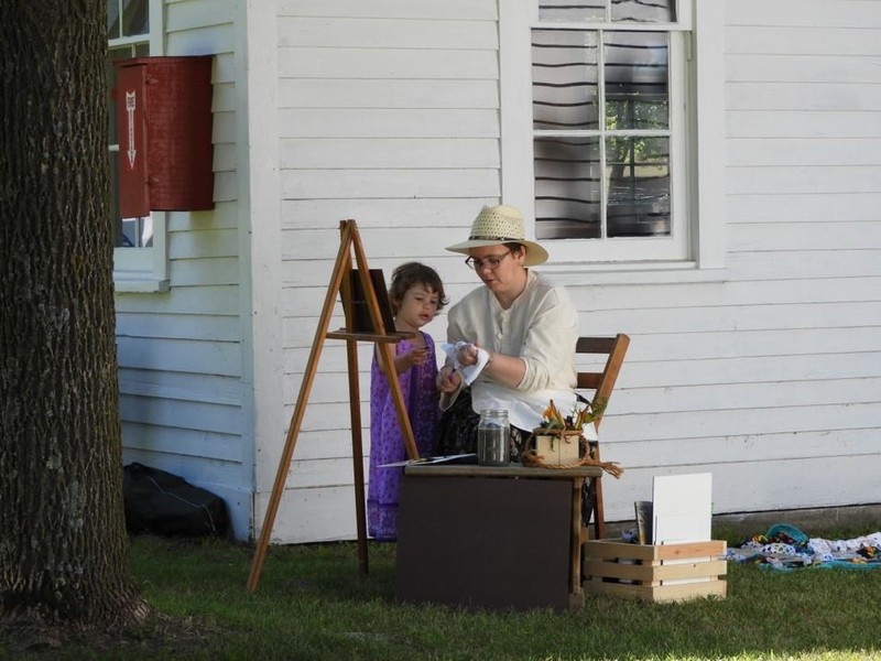 Assistant Director Betty Anne demonstrating traditional painting skills to her daughter during Heritage Days 2018