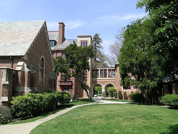 Grassy academic quad and sidewalk leading towards the arcade next to Hobart Hall