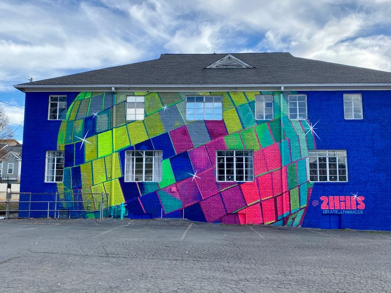 A large, neon colored disco ball is painted on the entire side of the wall.