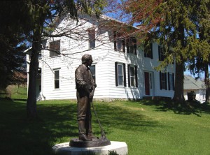 Side shot of home with statue to Joseph Smith to mark his 3-week employment under Stowell and his living in the home for a brief time with Emma