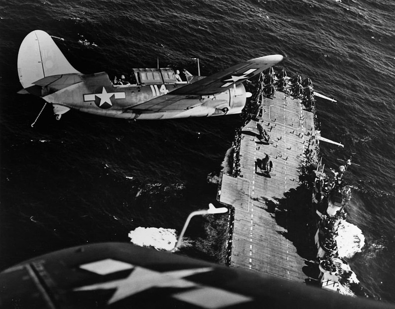 Two SBC Dauntless aircraft bank over the flight deck of the USS Hornet during World War II. (Wikimedia)