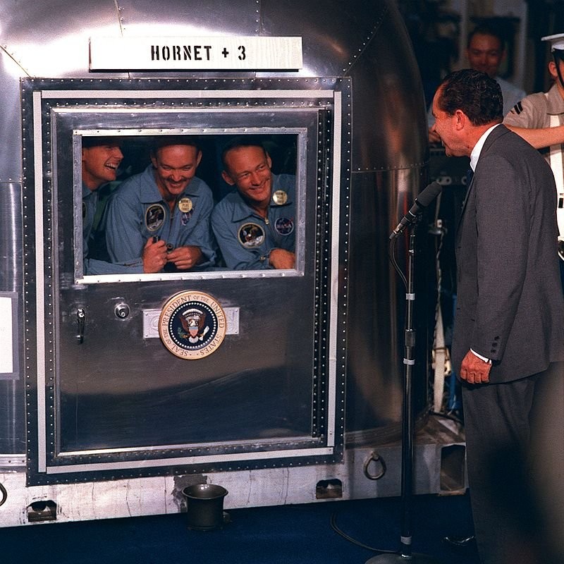 President Richard Nixon greets the Apollo 11 astronauts during their quarantine aboard USS Hornet after their successful return from the moon. Left to right: Neil Armstrong, Michael Collins, and Buzz Aldrin.