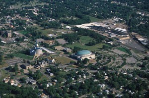 Aerial view of Temple Lot: Community of Christ temple and auditorium: largest buildings. Church of Christ's building is the small white sided one in between the former. The LDS visitors center is the rectangular one near rounded top structure.   