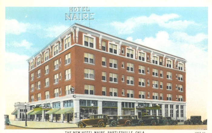 An old postcard featuring cars parked in front of Hotel Maire.