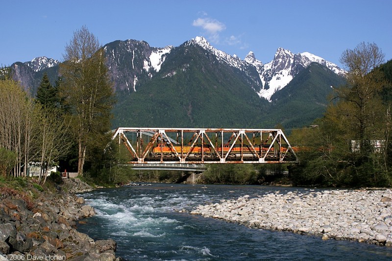 A train passes over the Skycomish River under the Cascade Mountains in Index Washington.