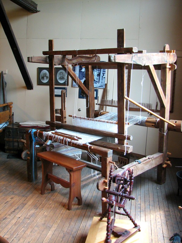 Vintage hand loom and small spinning wheel on display