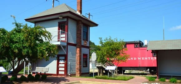 The Bowie Railroad Museum, with the tower, passenger shed, and caboose visible. Image by Henry Adams Consulting Engineers (reproduced under Fair Use).