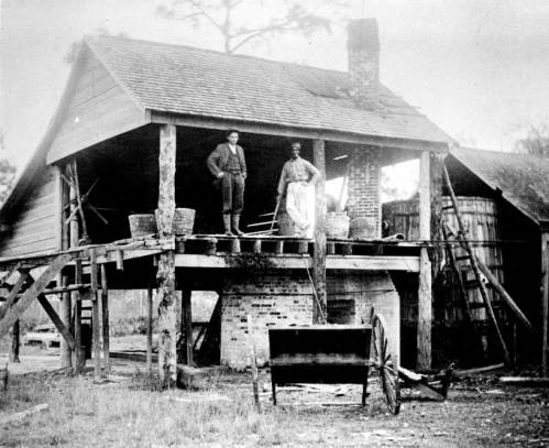 1910, front view of a turpentine still with chimney and large barrel