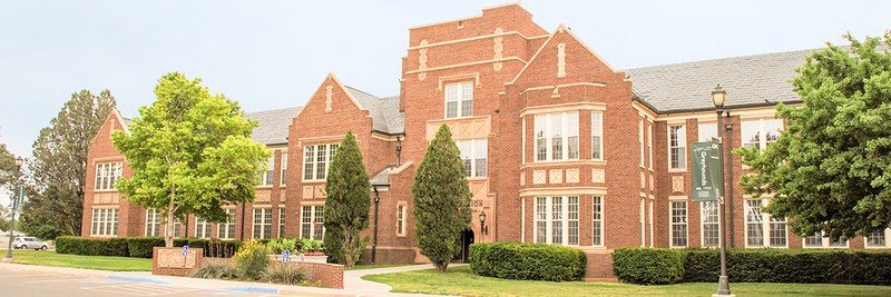 exterior of red brick building with landscaping
