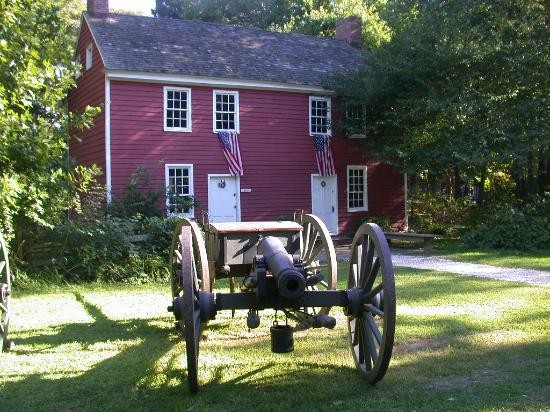 A canon sits in front of one of the buildings at the museum