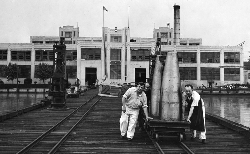 Workers push a flat car at the Naval Torpedo Station on the Potomac River in Alexandria (image from The Washington Post)